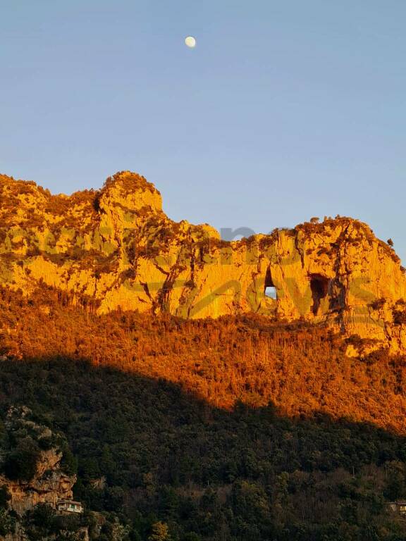 Positano, il tramonto veste d'oro le montagne con una luna che fa da custode